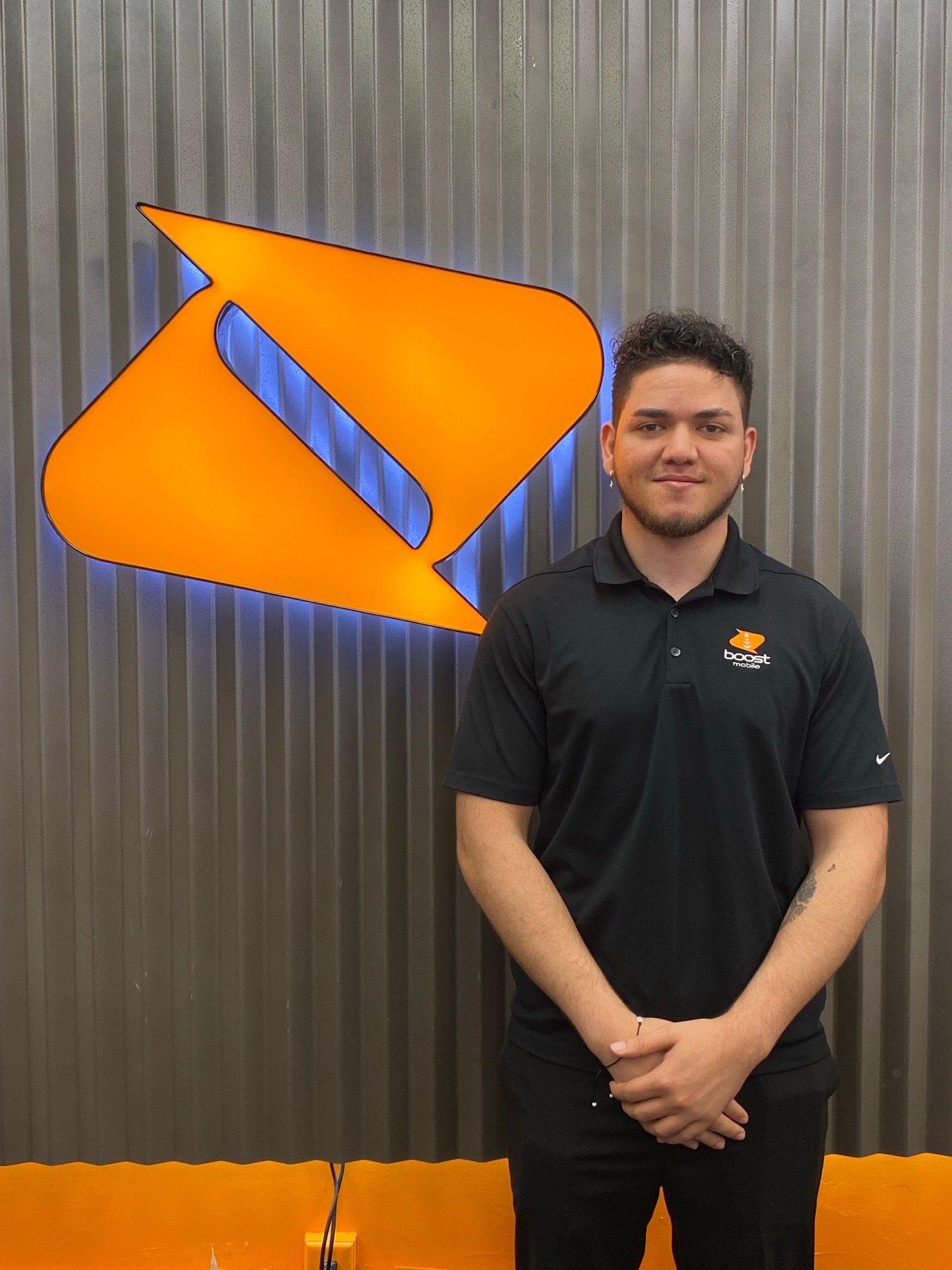 An RBFC team member in front of the Boost Mobile logo