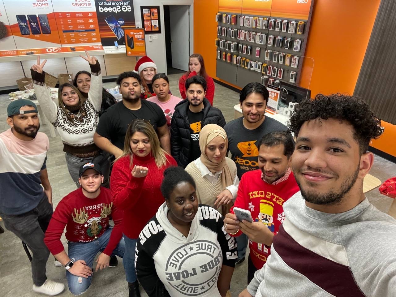 The RBFC team celebrating the holidays together inside a Boost Mobile store — family is at the heart of the business