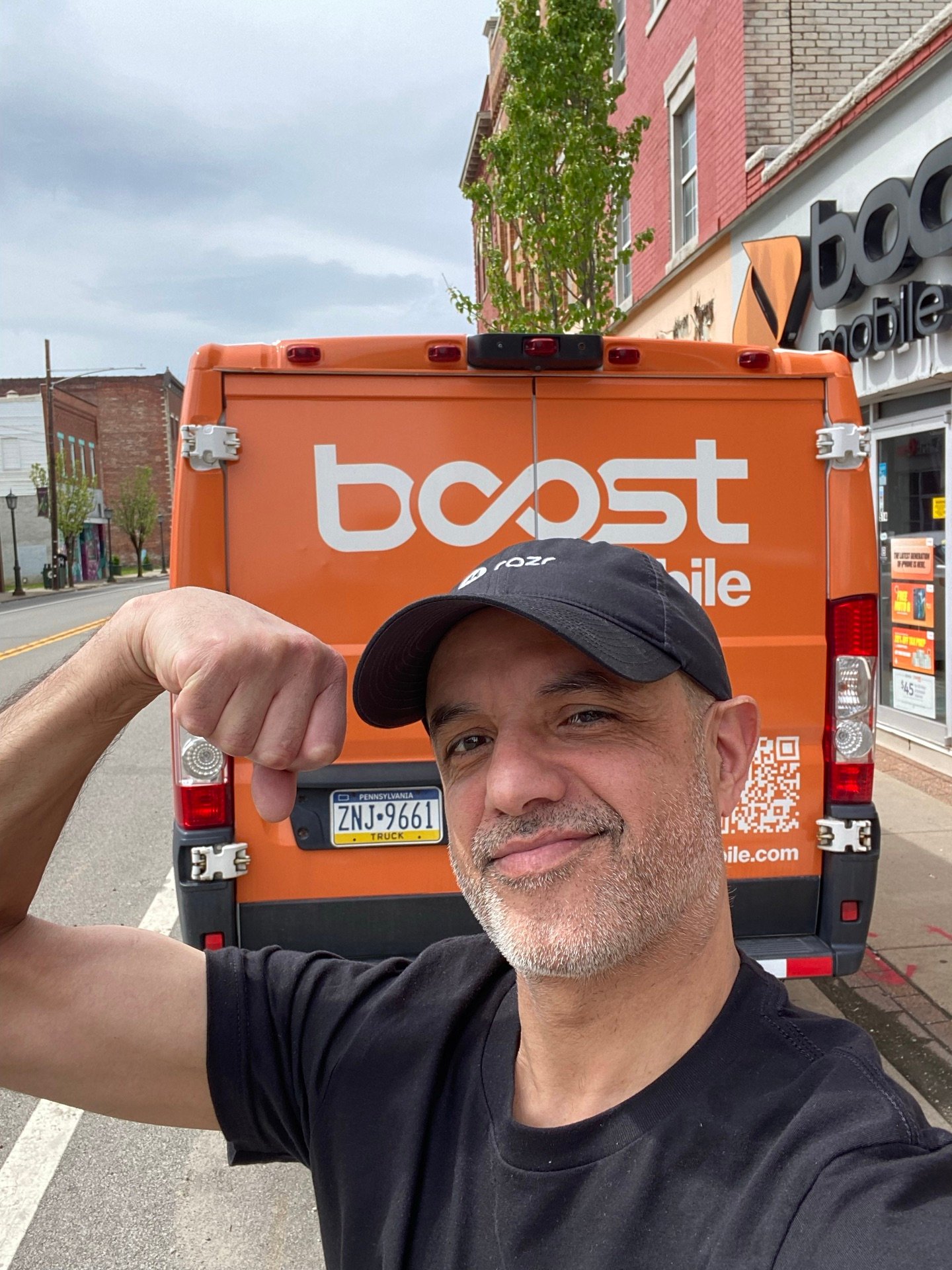 An RBFC team member in front of a Boost Mobile delivery van