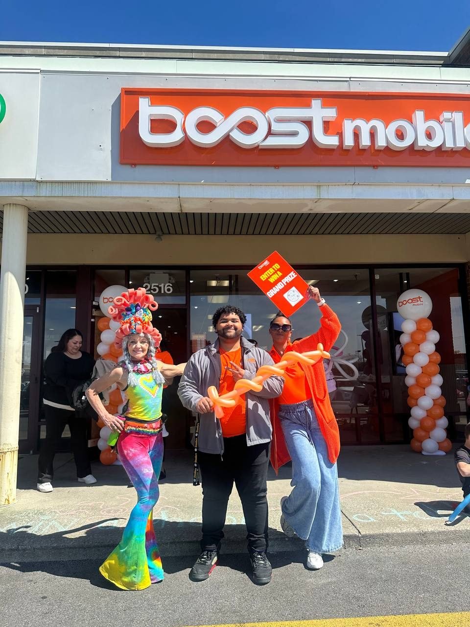 The RBFC team in front of a balloon-framed Boost Mobile storefront